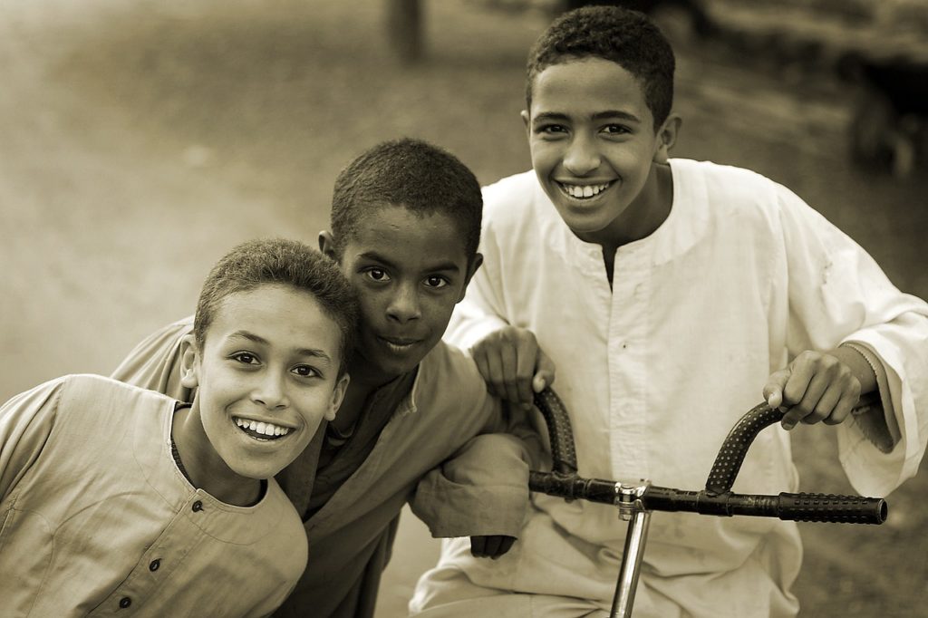 Three children together with one of them on bicycle