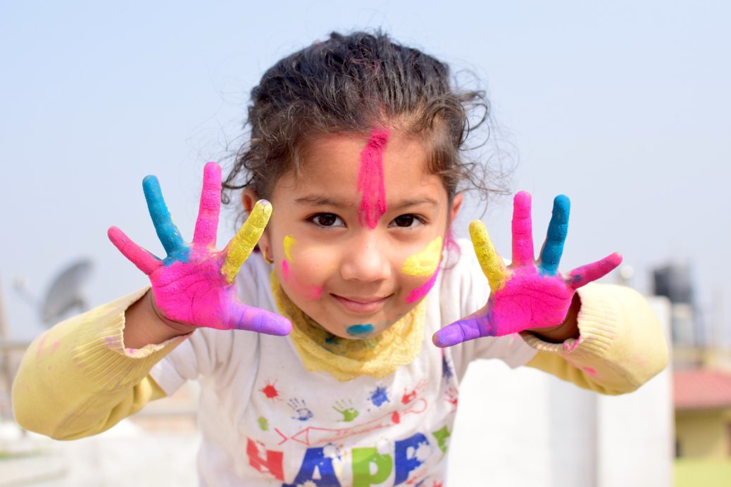 Child exploring imaginative play with Color powder on her palms